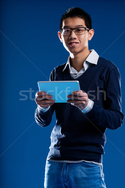 chinese guy smiling holding an ipad Stock photo © Giulio_Fornasar