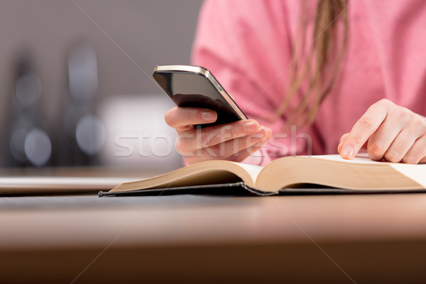 Woman using mobile phone while reading book Stock photo © Giulio_Fornasar