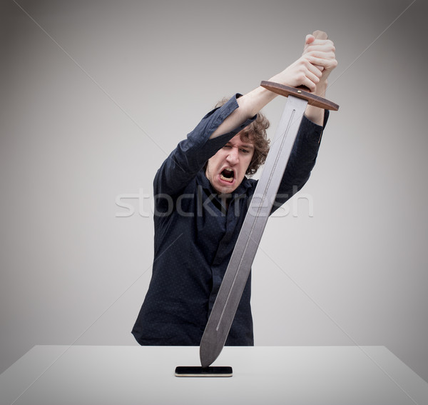 angry man hitting his phone with a sword Stock photo © Giulio_Fornasar
