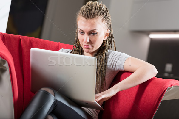Donna utilizzando il computer portatile poltrona confortevole Foto d'archivio © Giulio_Fornasar