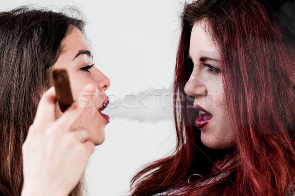 Bir sigara içme diğer bir kız iğrenç arkadaş Stok fotoğraf © Giulio_Fornasar