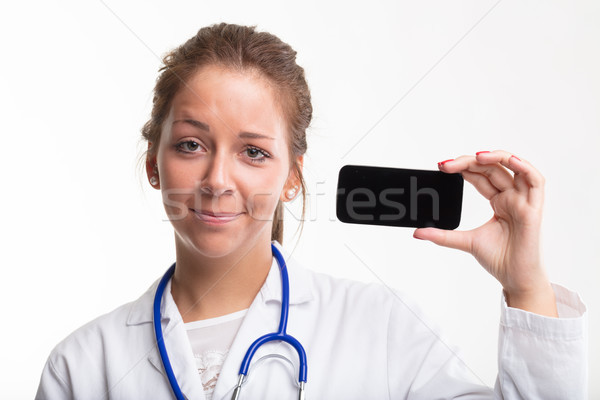 Young doctor holding up a blank smartphone Stock photo © Giulio_Fornasar