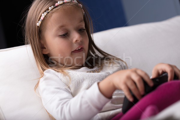 [[stock_photo]]: Petite · fille · jouer · joystick · Kid · séance · canapé