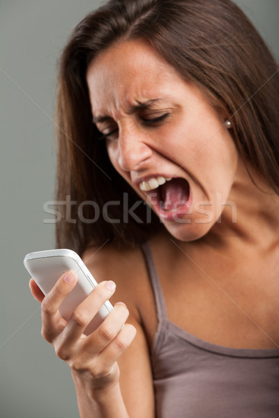 Frustrated young woman screaming at her mobile Stock photo © Giulio_Fornasar