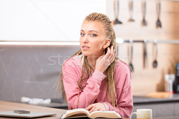 Young long-haired woman sitting with book at table Stock photo © Giulio_Fornasar