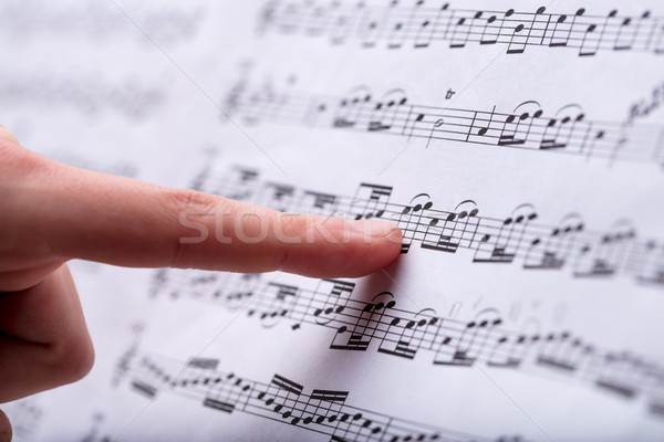 notes on a musical score spotted by finger Stock photo © Giulio_Fornasar