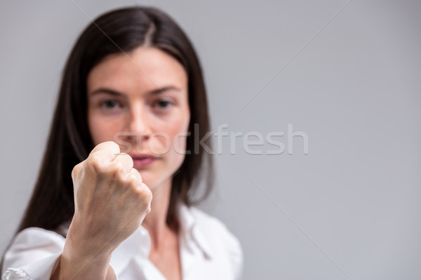 Stock photo: Portrait of young woman threatening with fist