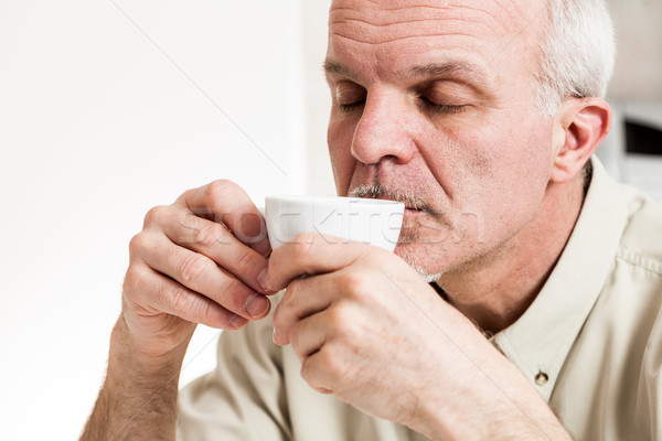 Stock photo: Contented man sipping from tea cup