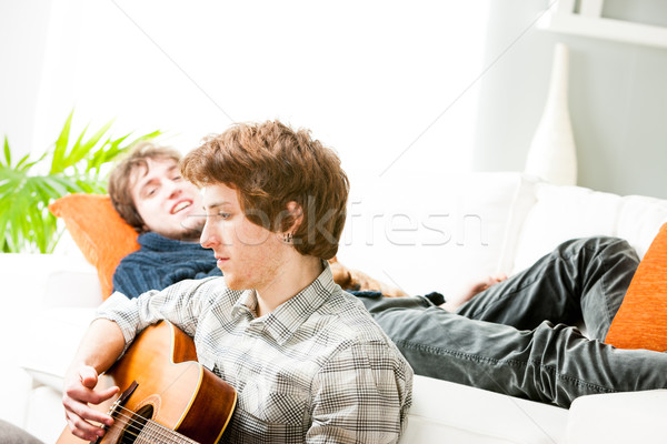 Young man playing guitar on the living room floor Stock photo © Giulio_Fornasar