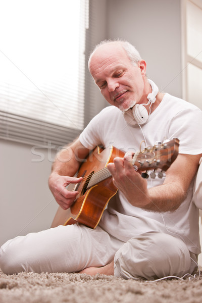 [[stock_photo]]: Homme · mûr · jouer · guitare · maison · tapis · salon