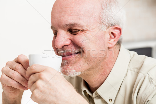 Grinning man sipping from tea cup Stock photo © Giulio_Fornasar