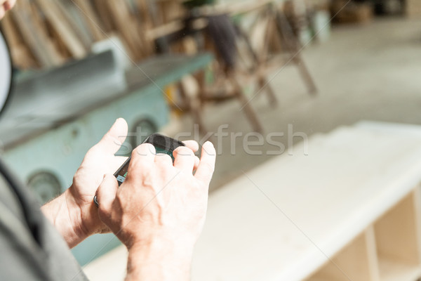 hands of a woodworker using a mobile Stock photo © Giulio_Fornasar