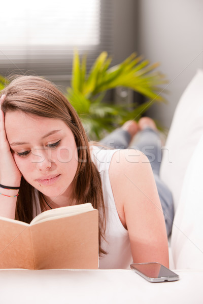 Ragazza studiare divano lettura soggiorno telefono Foto d'archivio © Giulio_Fornasar