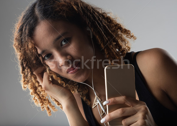 Afro Colombian girl listening music on her smart phone Stock photo © Giulio_Fornasar