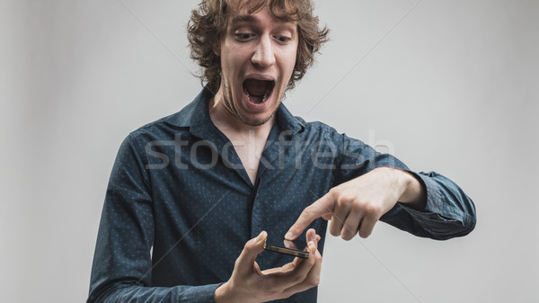 man amused by his smartphone features Stock photo © Giulio_Fornasar