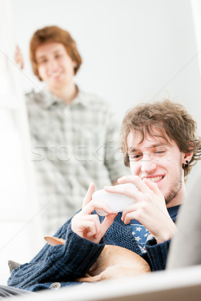 Stock photo: One young man sits with his dog and cell phone