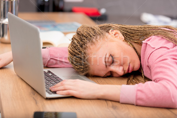 Exhausted young woman asleep at her laptop Stock photo © Giulio_Fornasar