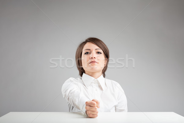 Determined young woman with her fist on the table Stock photo © Giulio_Fornasar