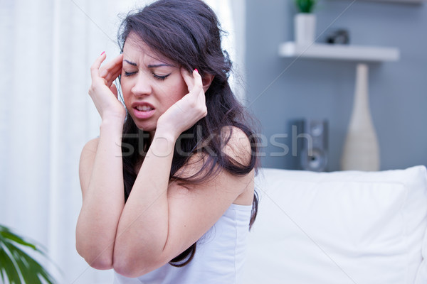 girl with painful headache in her living room Stock photo © Giulio_Fornasar