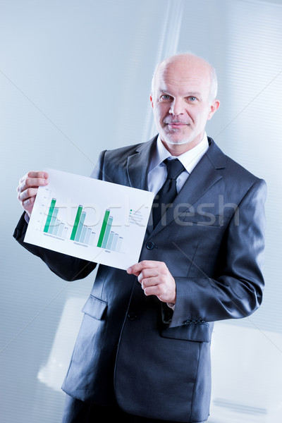 man showing up some graphs with shy smile Stock photo © Giulio_Fornasar