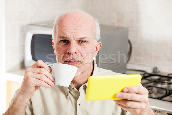 Concerned man holding cup and digital reader Stock photo © Giulio_Fornasar