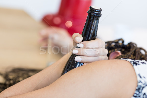 Bottle in hand of lying woman Stock photo © Giulio_Fornasar