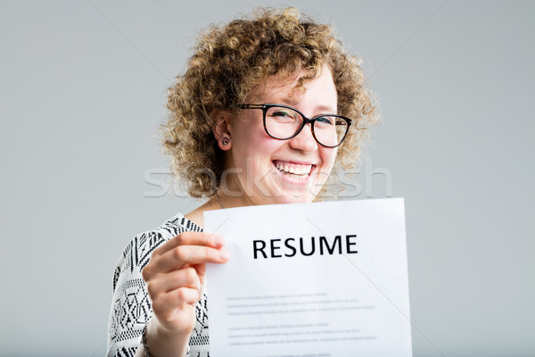 curly woman showing her resume on a gray background Stock photo © Giulio_Fornasar