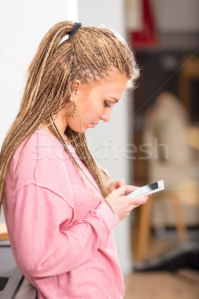Trendy blond woman with braids using a mobile Stock photo © Giulio_Fornasar