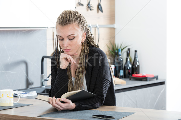 woman in her kitchen reading a book Stock photo © Giulio_Fornasar
