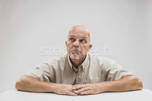 Thoughtful older balding man sitting at a table Stock photo © Giulio_Fornasar