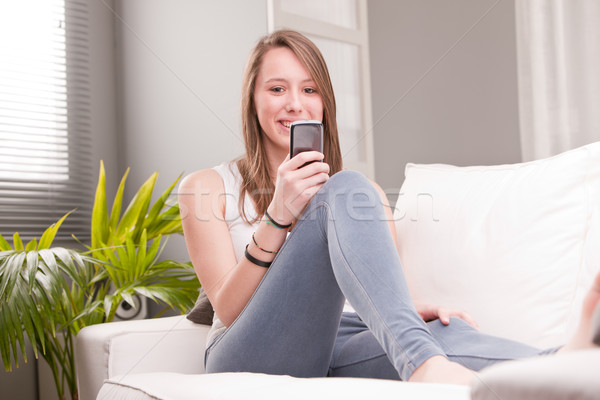 Sorridente menina telefone telefone móvel casa sala de estar Foto stock © Giulio_Fornasar