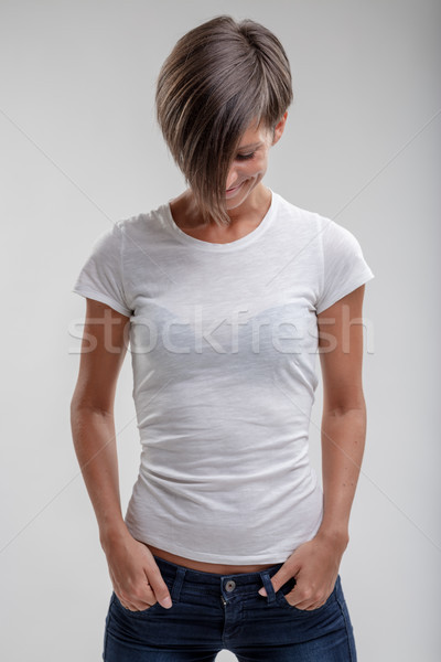 Fit woman in jeans looking down with a smile Stock photo © Giulio_Fornasar