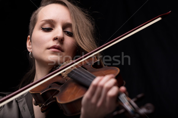 Stock photo: passionate violin musician playing on black background