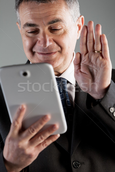 Stock photo: Businessman video conferencing on his tablet