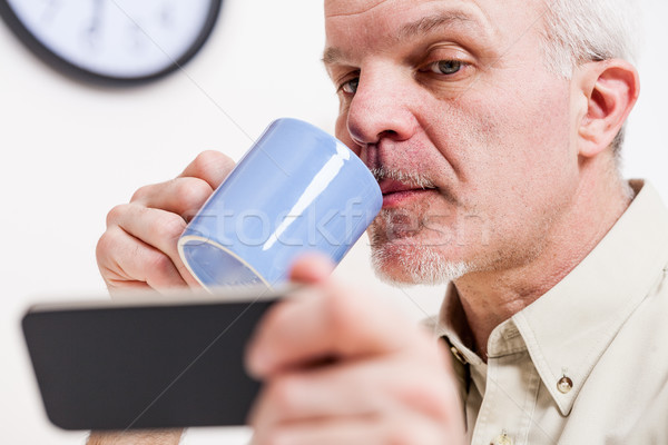 Homme mûr lecture smartphone écran déjeuner pause café [[stock_photo]] © Giulio_Fornasar