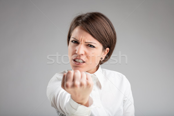 Angry woman shaking her fist at the camera Stock photo © Giulio_Fornasar
