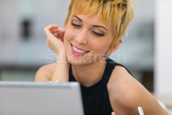 Smiling young woman looking at laptop Stock photo © Giulio_Fornasar
