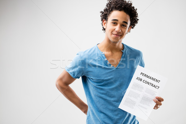 Stock photo: permanent job contract shown by a young man