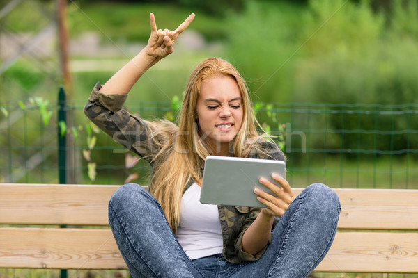 excited metal lover watching something on her tablet Stock photo © Giulio_Fornasar