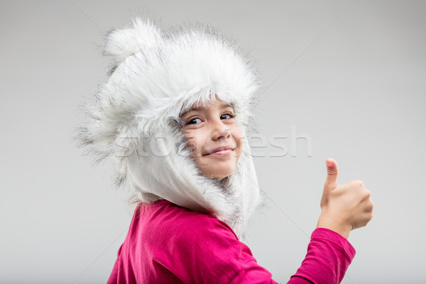 Preteen girl wearing fluffy cap giving thumb up Stock photo © Giulio_Fornasar