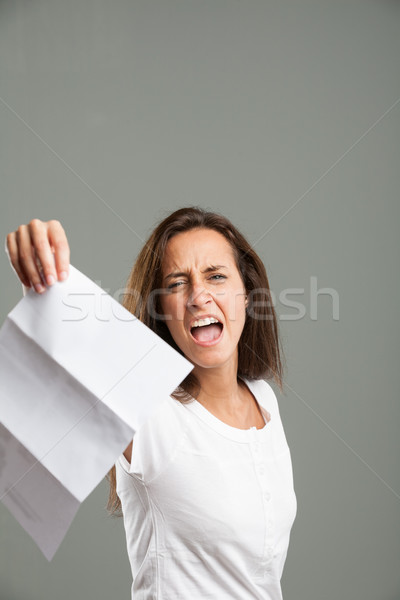 Distressed young woman holding up a document Stock photo © Giulio_Fornasar