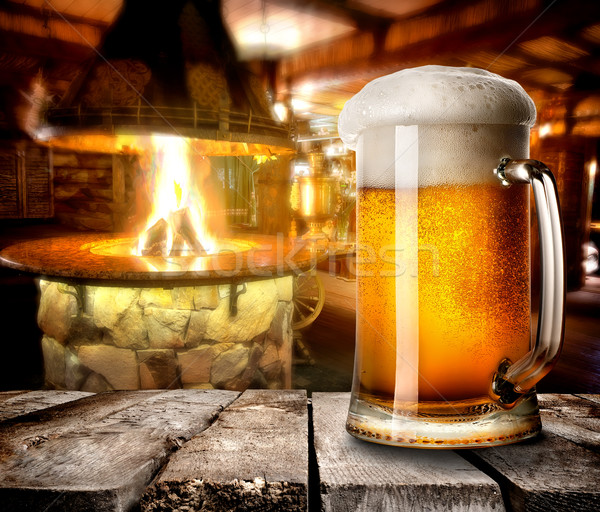Schiumoso birra mug tavolo in legno bar fuoco Foto d'archivio © Givaga