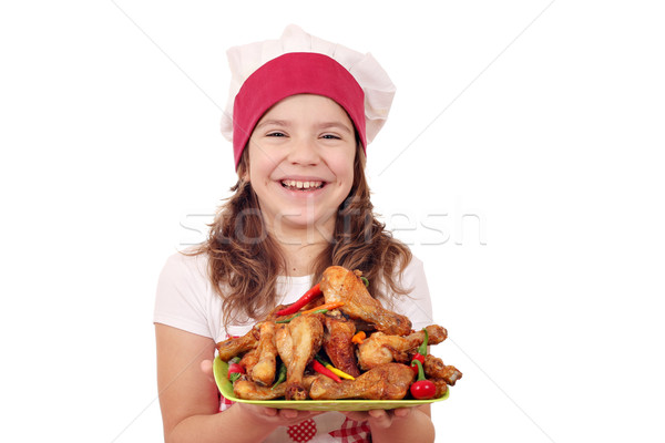 happy little girl cook with chicken drumstick Stock photo © goce