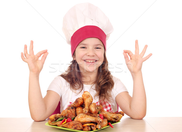 happy little girl cook with chicken drumstick and ok hand sign Stock photo © goce
