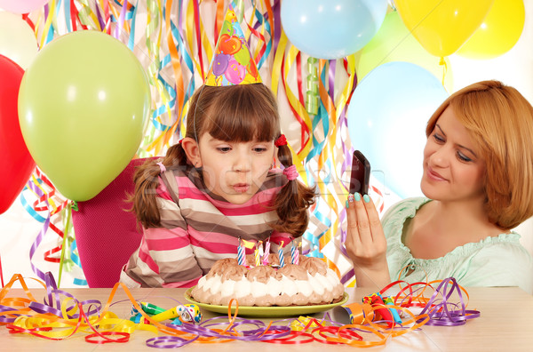 Mother taking picture while daughter blowing the candles on the  Stock photo © goce