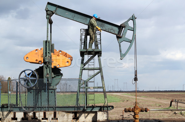 Stock photo: oil and fuel industry oil worker standing on the pump jack