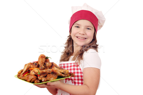 happy little girl cook with chicken drumstick on plate Stock photo © goce