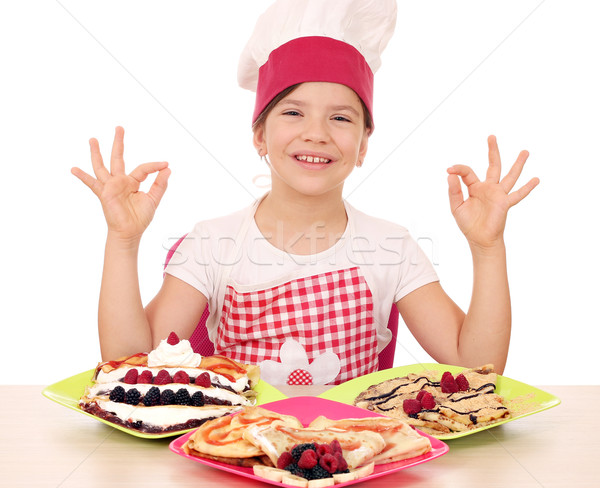 happy little girl cook with delicious crepes on table and ok han Stock photo © goce