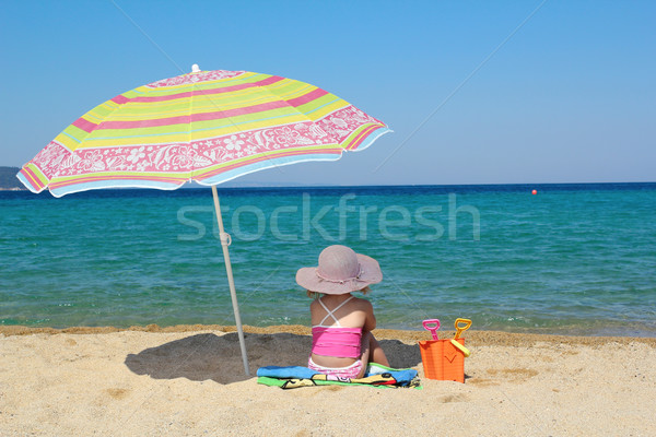 Fetita şedinţei plajă umbrela de soare copil albastru Imagine de stoc © goce