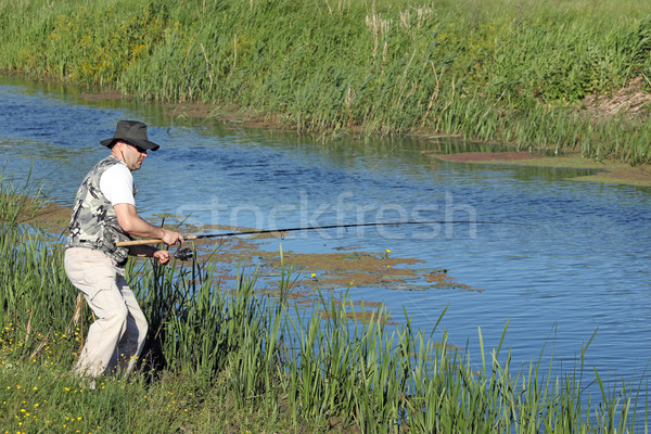 fisherman catching fish on river Stock photo © goce